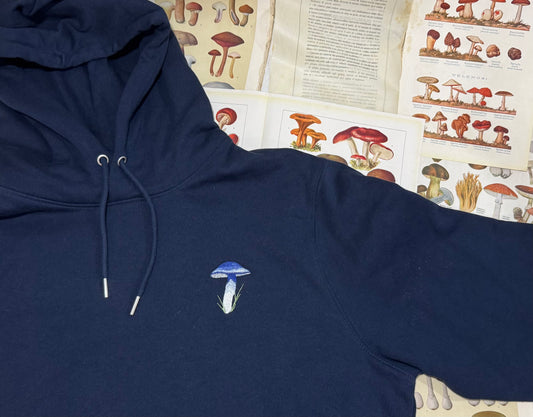 Flat lay shot of a navy hoodie with an embroidered Brightsky Pinkgill mushroom